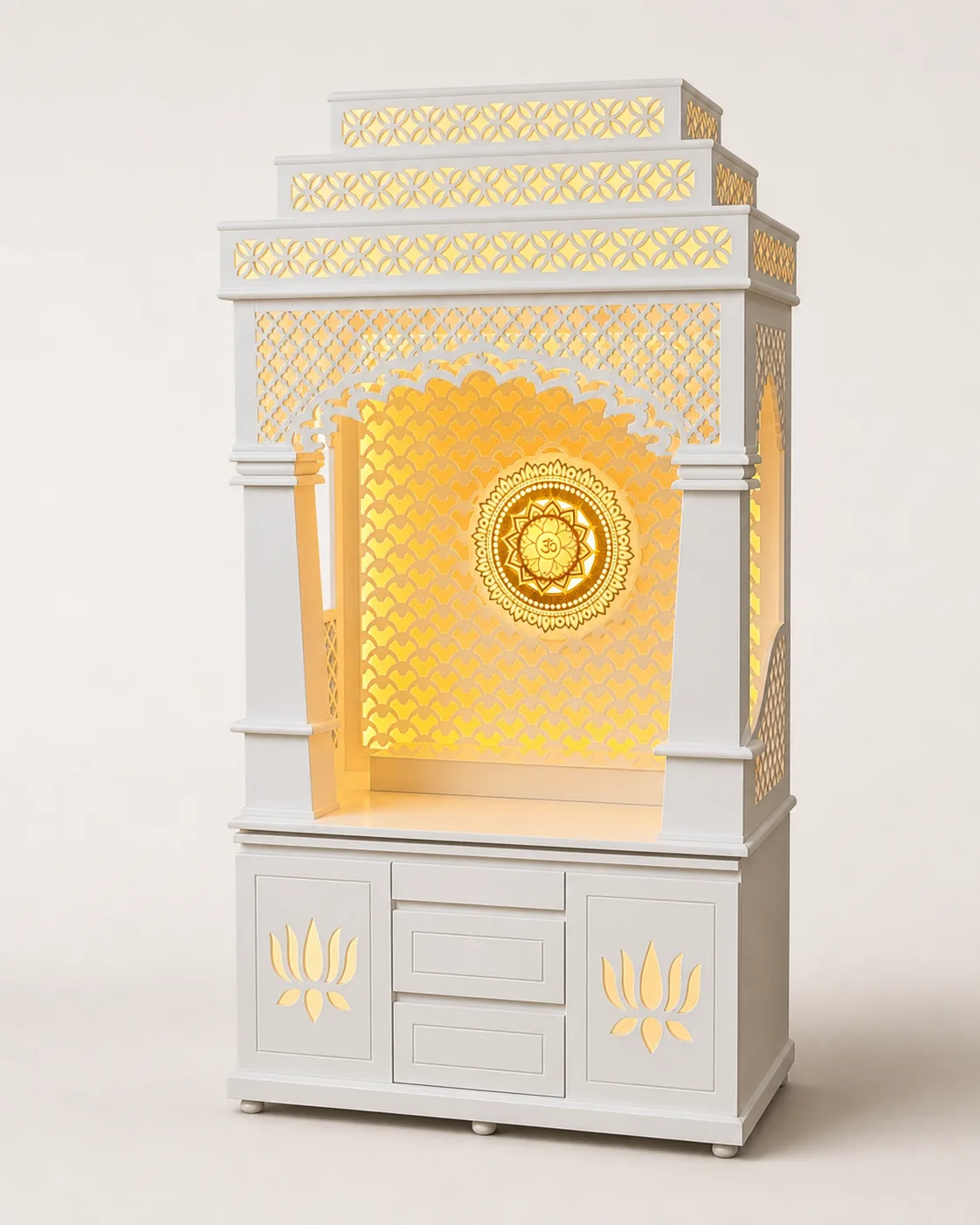 White tiered mandir unit with amber-lit fish-scale lattice arch and carved lotus motifs on the base doors.